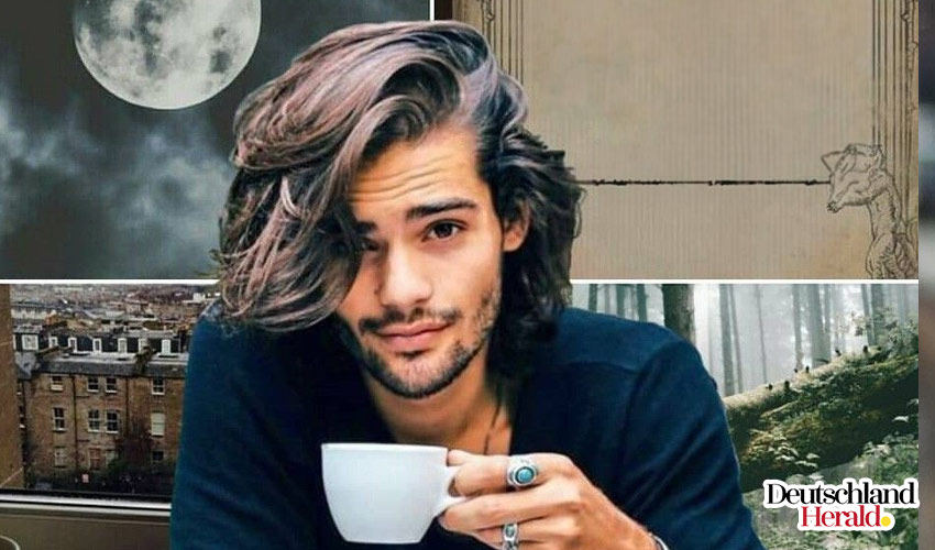A man with long hair drinking coffee